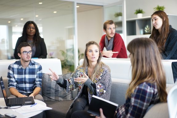 Gruppendiskussion mit mehreren Personen in einem modernen Büro setting.
